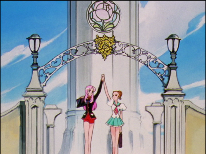 Utena and Wakaba walk under the arch of the Academy’s entrance, holding up their hands to make an arch of their own.
