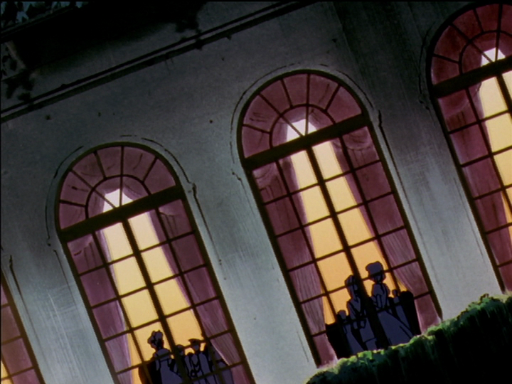 From outside, we see silhouettes of the party crowd inside through the windows.