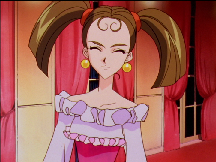 Keiko wears large, round, yellow, dangling earrings and a clown-like dress.