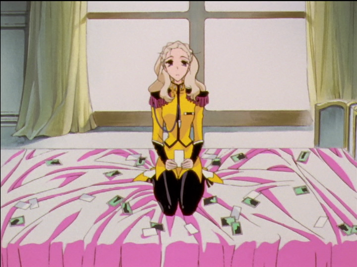 Photos are scattered over a pink blanket on a bed, Nanami sitting among them.