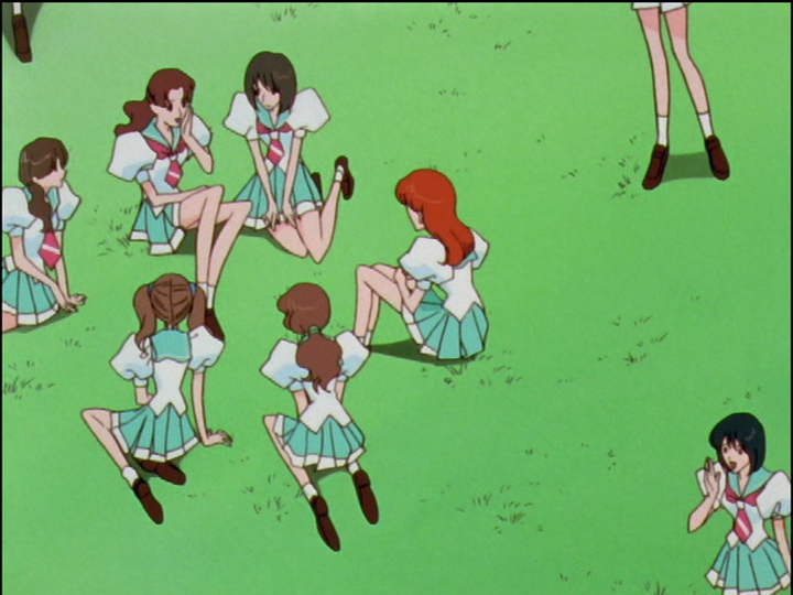 Girls are sitting on the grass, talking.