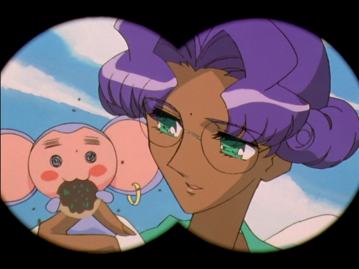 Chu-Chu is eating a cookie, as seen through opera glasses.